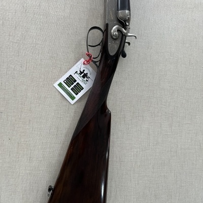 Espingarda de canos duplos com coronha de madeira escura e etiqueta