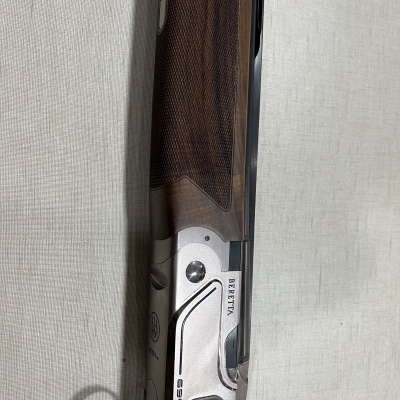 Arma de caça Beretta com detalhes em madeira e metal prateado