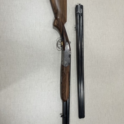 Espingarda de canos sobrepostos com cabo de madeira castanha e canos metálicos pretos
