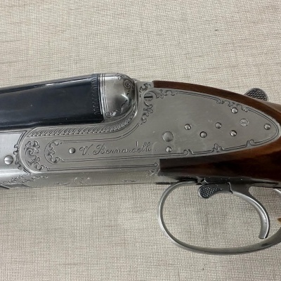 Espingarda de canos duplos com gravações e madeira sobre fundo bege