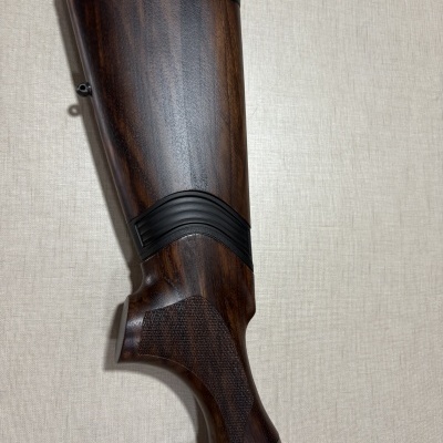 Coronha de espingarda de madeira escura com detalhes emborrachados e metal com gravação