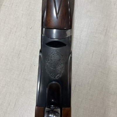 Espingarda com detalhes em madeira castanha e metais pretos gravados