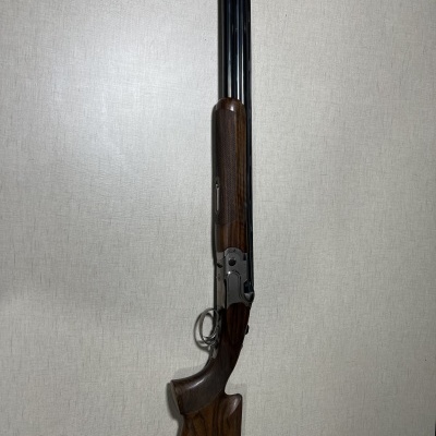 Espingarda de canos duplos com coronha de madeira castanha escura e metal preto fosco