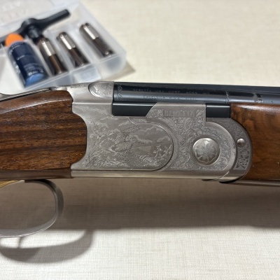 Espingarda Beretta em madeira castanha com metal gravado prateado e preto
