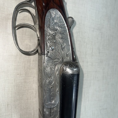 Espingarda de caça com madeira escura e metal gravado, gatilho duplo