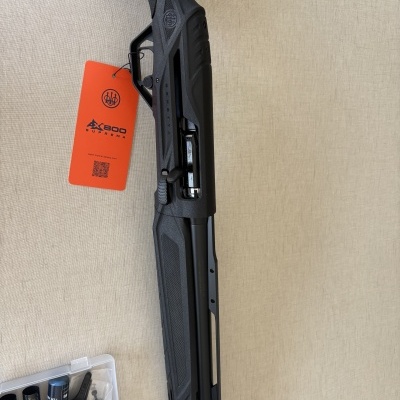 Espingarda Beretta EX800 Suprema preta com etiqueta laranja e acessórios em caixa transparente