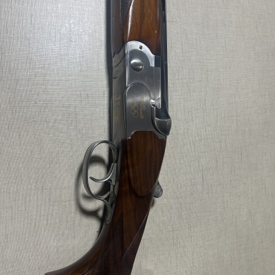 Espingarda de caça em madeira polida e metal prateado com gravações douradas