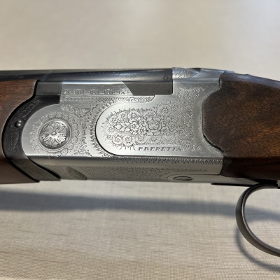 Espingarda com caixa metálica cinza decorada e empunhadura de madeira