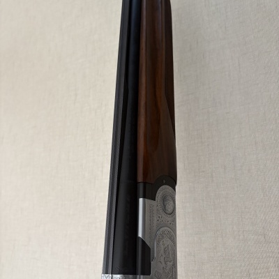 Carabina de caça em madeira, metal prateado gravado e cano preto