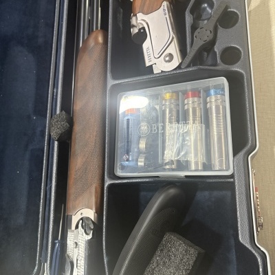 Mala para espingarda Beretta com partes da arma e acessórios organizados no interior em veludo azul