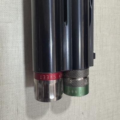 Duas armas de canos paralelos com extremidades coloridas em close-up