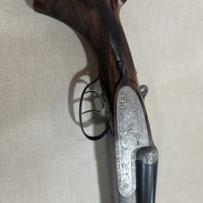 Espingarda de caça com madeira escura e metal prateado gravado