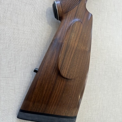 Coronha de arma de madeira castanha com textura polida e padrão quadriculado