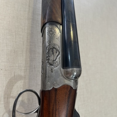 Espingarda cano duplo com madeira castanha e gravuras metálicas prateadas