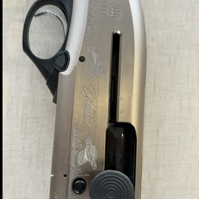 Espingarda Beretta com detalhes em metal prateado, punho preto e madeira, com gravações de aves e texto AlPINO BERETTA.