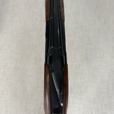 Espingarda de canos paralelos com coronha em madeira e detalhes metálicos