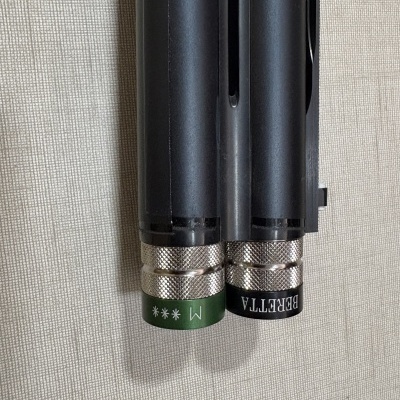 Extremidades metálicas prateadas de cana de pesca preta com inscrições BERETTA e M ***.