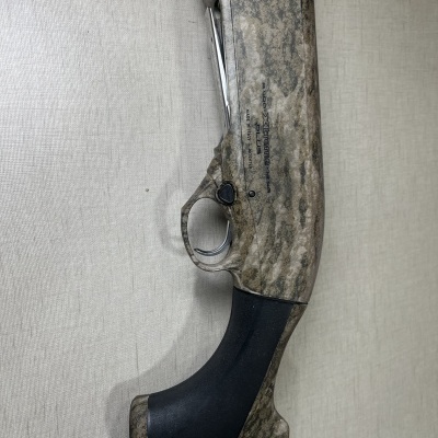 Espingarda camuflada com cabo preto e texto BENELLI ARMI URBINO - MADE IN ITALY