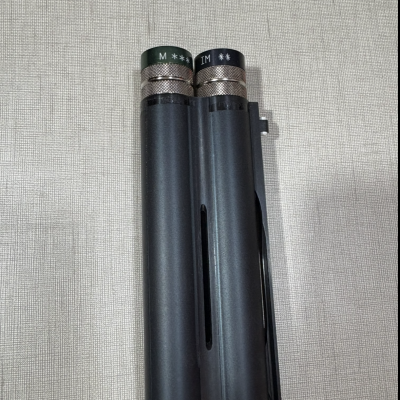 Peças cilíndricas metálicas pretas com detalhes prateados e texto no topo.