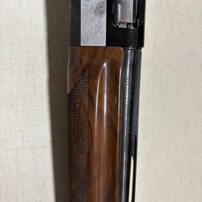 Espingarda com punho de madeira e detalhes metálicos gravados