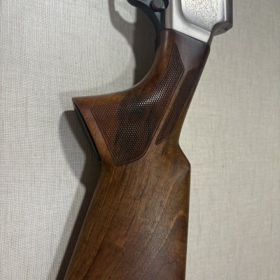 Parte da coronha de madeira e parte do mecanismo de uma arma de fogo