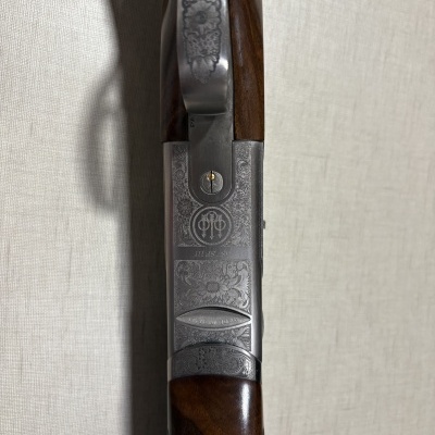 Parte superior de arma de fogo com pegada em madeira e metal prateado gravado