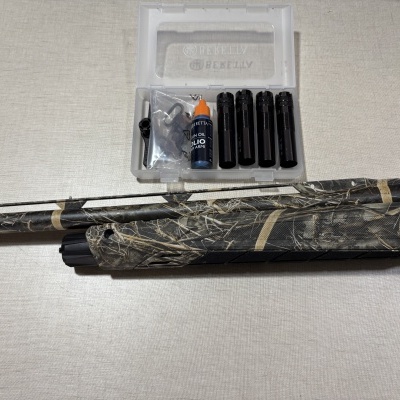 Acessórios para espingarda Beretta em estojo plástico com óleo, tubos e espingarda camuflada