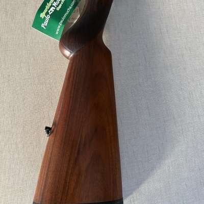 Cabo e coronha de espingarda em madeira castanha com etiqueta verde