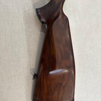 Cabo de espingarda em madeira castanha com textura e acabamento.