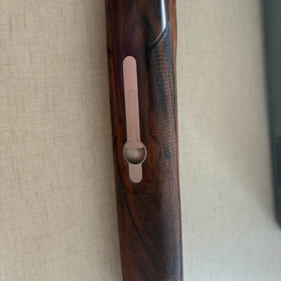 Coronha de arma de fogo em madeira escura com metal embutido