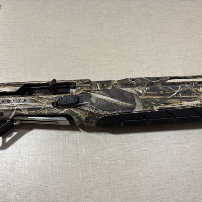 Espingarda camuflada com texto CERATA sobre superfície clara