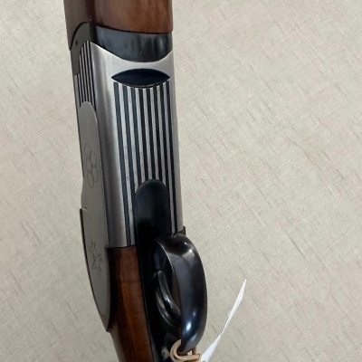 Espingarda com madeira castanha e metal riscado preto e prateado