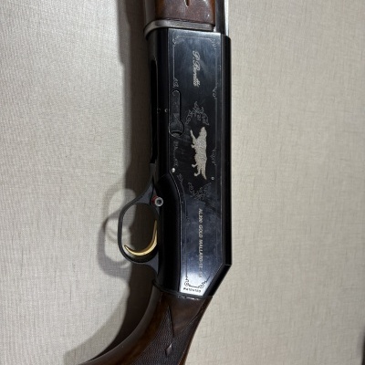Espingarda com madeira castanha e corpo metálico preto gravado