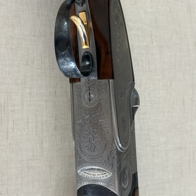 Parte lateral de espingarda em madeira e metal com inscrição BERETTA MADE IN ITALY