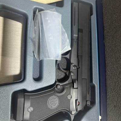 Revólver preto com empunhadura texturizada em estojo azul