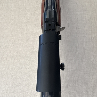 Parte superior de uma espingarda com coronha em madeira e cano preto com acessório FAST FIERCE
