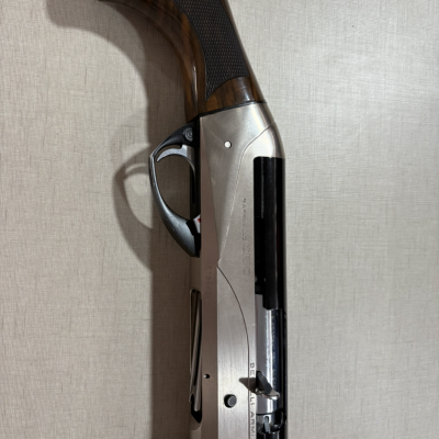 Espingarda com madeira escura e corpo metálico prateado