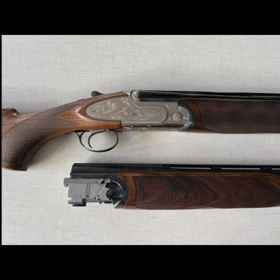 Espingarda desmontada com armação metálica gravada e madeira castanha trabalhada