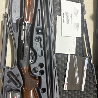 Estojo com espingarda Benelli, acessórios e manuais.
