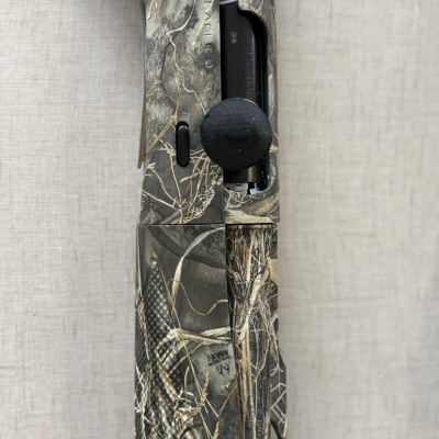 Detalhe de arma com padrão camuflado e texto MAX4