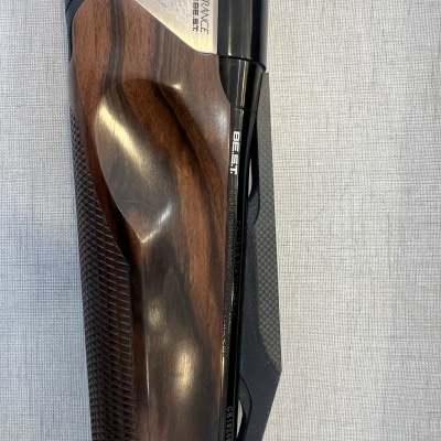 Espingarda com cabo de madeira polida e detalhes gravados em metal preto