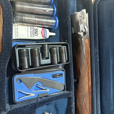 Mala azul com espingarda, tubos transparentes, bisnaga de graxa universal para armas e ferramentas metálicas