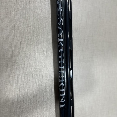 Cabo preto brilhante com texto 'CAESARGUERINI' em fundo bege