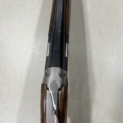 Espingarda de canos paralelos com madeira escura e metais cinza prateados