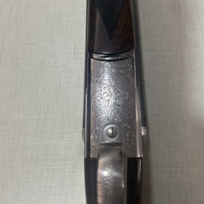 Espingarda com detalhes em metal prateado gravado e cabo de madeira escura