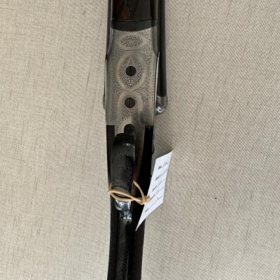 Espingarda cano duplo com cabo de madeira escura e detalhes em metal prateado