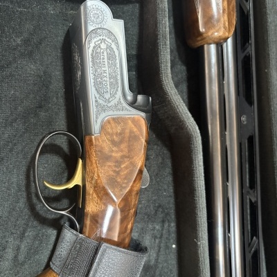 Espingarda Perazzi MX2005 com acabamento em madeira e detalhes em metal dentro de estojo