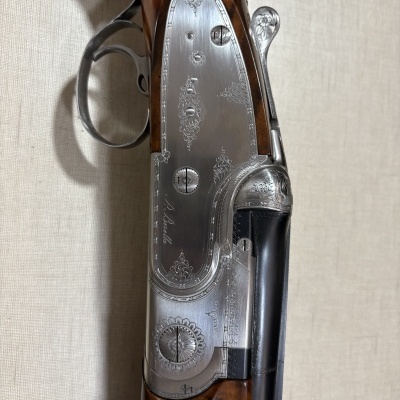 Espingarda de caça com coronha em madeira castanha e placa lateral metálica gravada