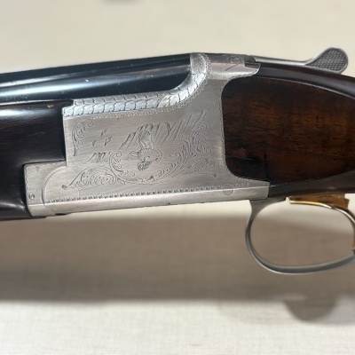Espingarda de caça com corpo em madeira castanha e metal prateado com gravura
