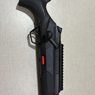 Parte de uma arma de fogo preta com cabo texturizado e inscrição Beretta BRX1